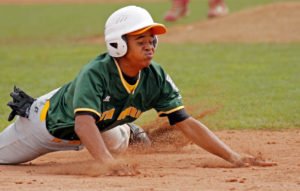 Young baseball player sliding home