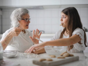 Grandma and granddaughter laughing baking cookies