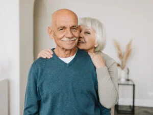 Wife kisses husband over shoulder